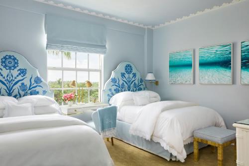 ein blau-weißes Schlafzimmer mit 2 Betten und einem Fenster in der Unterkunft The Colony Hotel in Palm Beach