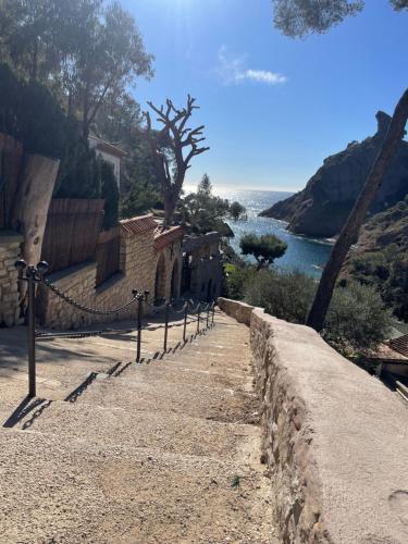 un chemin de pierre à côté d'un mur à côté d'un plan d'eau dans l'établissement T2 La Ciotat appartement vieux port, à La Ciotat