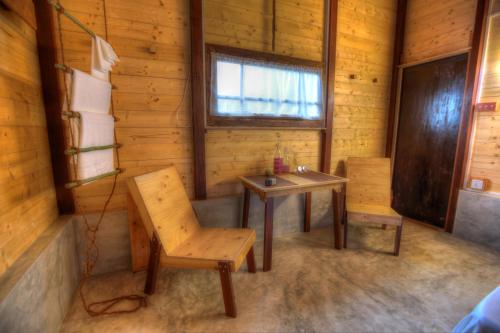 a room with a table and a chair in a log cabin at Beverly Hill Cabanas Hikkaduwa in Hikkaduwa