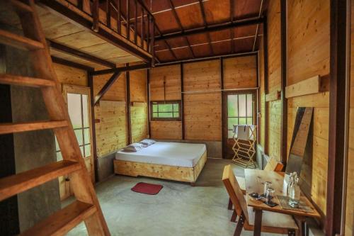 a bedroom in a wooden cabin with a bed and a table at Beverly Hill Cabanas Hikkaduwa in Hikkaduwa