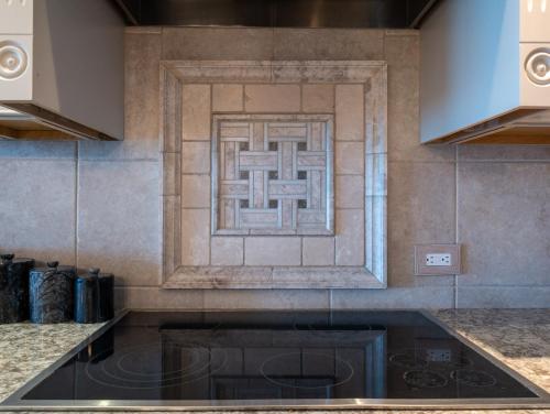 a kitchen with a stove and a tile wall at Pelican Watch #906 in Carolina Beach