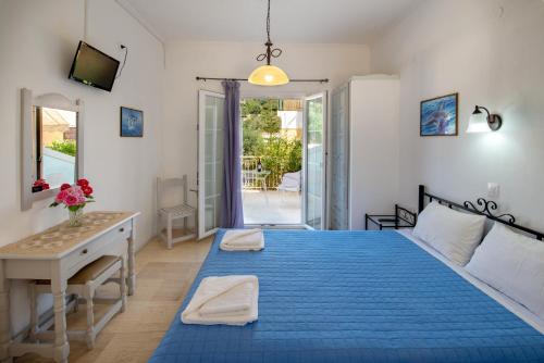 a bedroom with a blue bed and a desk at Soustas Apartments in Longós