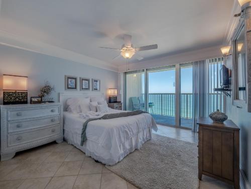 a bedroom with a bed with a view of the ocean at Pelican Watch #906 in Carolina Beach