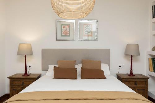a bedroom with a white bed with two lamps at Partacua by BeValle in Tramacastilla de Tena