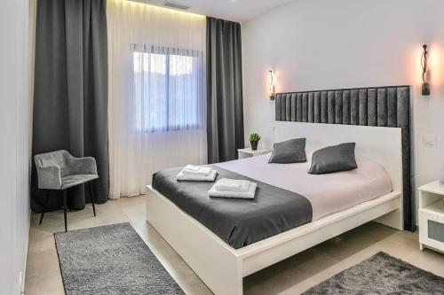 une chambre avec un grand lit et une chaise dans l'établissement Villa du Golf, à Sainte-Maxime