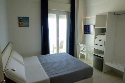 a white bedroom with a bed and a window at San Marco in Marotta