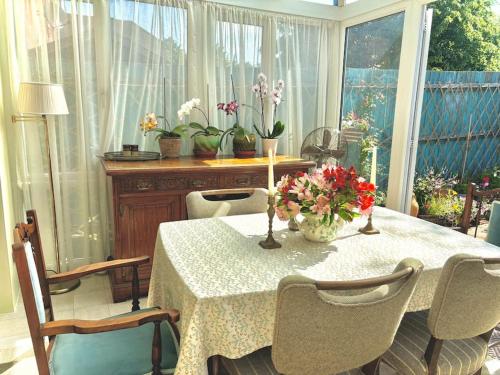 a table with flowers on it in a room at 2 bedroom house in Chichester near Goodwood and Wittering beaches in Chichester