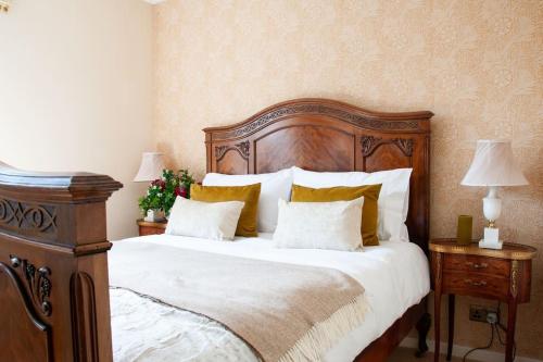 a bedroom with a large wooden bed with pillows at 2 bedroom house in Chichester near Goodwood and Wittering beaches in Chichester