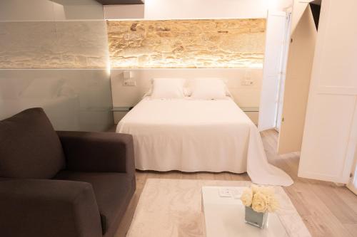 a bedroom with a bed and a couch and a table at Hotel Montes in Santiago de Compostela