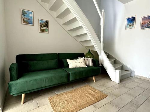 a green couch in a living room with a staircase at Evasion de rêve à Casa Nina in Borgo