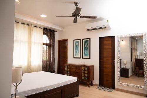 um quarto com uma cama e um espelho em TERRA VERDE ! A Sunset Villa at Varca, South Goa ! em Varca