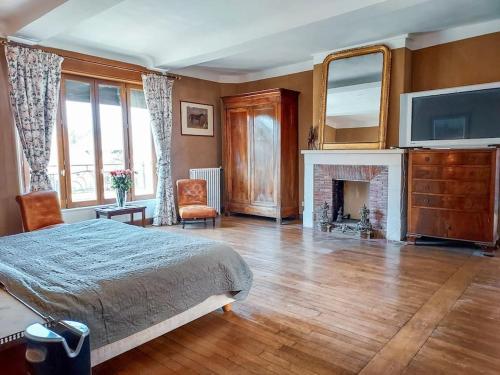 - une chambre avec un lit, une cheminée et une télévision dans l'établissement Le Haras des Charmilles, à Varaville