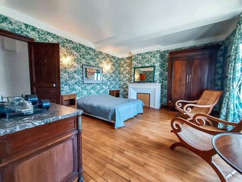 une chambre avec un lit et une cheminée dans l'établissement Le Haras des Charmilles, à Varaville