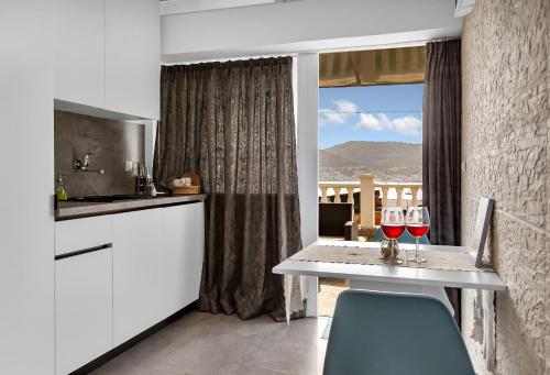 a kitchen with a table with two glasses of wine at Casa Del Porto - Vis in Vis
