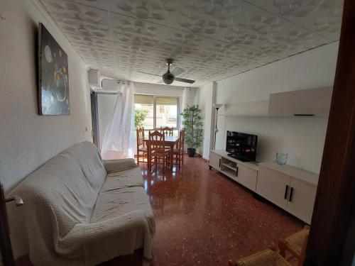 ein Wohnzimmer mit Sofa und Tisch in der Unterkunft Apartamento en Playa de Bellreguard in Bellreguart