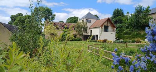 un jardin avec une maison en arrière-plan dans l'établissement Maison en campagne - Bienvenue Chez Aurélie & Arnaud, à Laleu