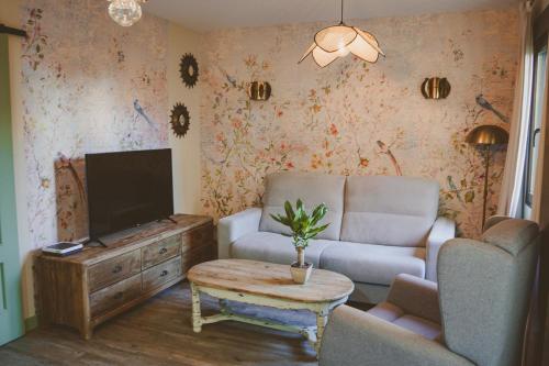 a living room with a tv and a couch and a table at Petit Candeleda in Candeleda