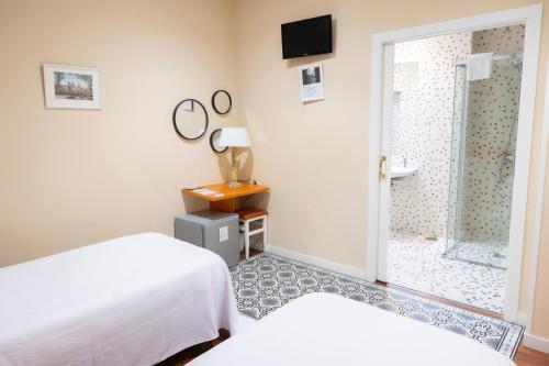 a bedroom with two beds and a sliding glass door at Hotel Montes in Santiago de Compostela