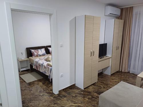 a bedroom with a bed and a tv and a cabinet at Prenoćište SILVER LUX Srebrno Jezero in Veliko Gradište