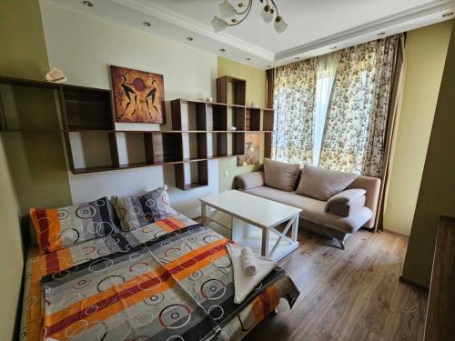Un dormitorio con una cama, un sofá y una mesa. en Europroperties Zlatna Kotva Apartments, en Golden Sands
