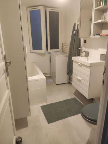 une salle de bain blanche avec des toilettes et un lavabo dans l'établissement Charming apartment 40 m2, 10th, à Paris