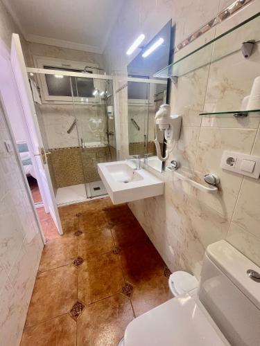 a bathroom with a toilet and a sink and a shower at Balnea Baiona in Baiona