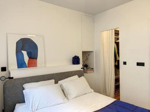 - une chambre avec un lit et un tableau au-dessus dans l'établissement Appartement Art Bougee Montmartre, à Paris
