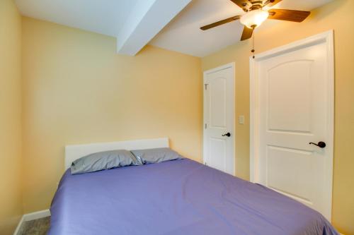 a bedroom with a purple bed and a ceiling fan at Cozy Goode Cabin with Deck about 17 Mi to Lynchburg in Goode