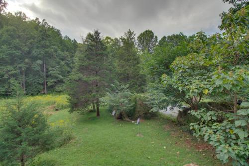 a garden with trees and grass and a pond at Cozy Goode Cabin with Deck about 17 Mi to Lynchburg in Goode