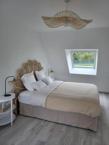 une chambre avec un grand lit et une fenêtre dans l'établissement Les Côtes Normandes, à Lantheuil