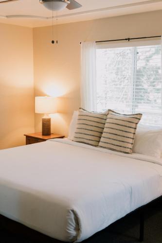 a bedroom with a white bed with a window at The Long Barn Lodge in Long Barn