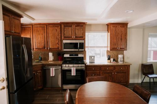 a kitchen with wooden cabinets and a table and a refrigerator at The Long Barn Lodge in Long Barn