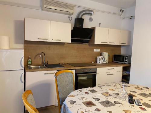 cocina con mesa, fregadero y microondas en Apartments Komadina, en Selce