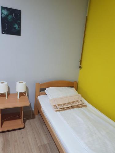 a small bedroom with a bed and a table at Vila Balkan in Kikinda