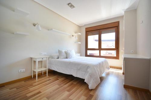 a white bedroom with a bed and a window at GALIHOST - Chalet con piscina en Vilagarcía de Arousa in Vilagarcia de Arousa