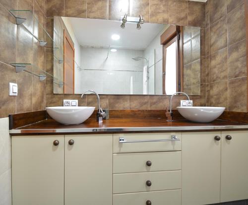 a bathroom with two sinks and a large mirror at GALIHOST - Chalet con piscina en Vilagarcía de Arousa in Vilagarcia de Arousa
