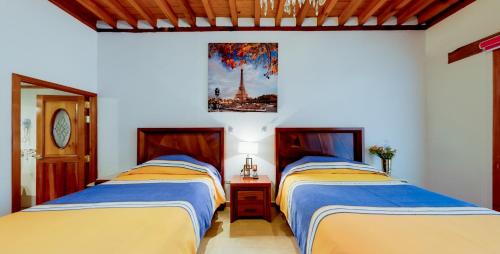 two beds sitting next to each other in a room at La Casa Baez in Pátzcuaro
