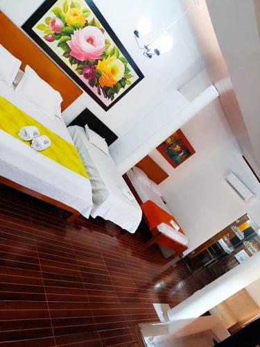 a bedroom with a bed with a flower picture on the wall at Hotel El Bosque Valledupar in Valledupar