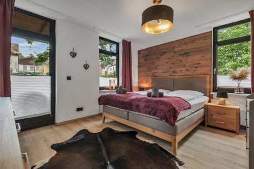a bedroom with a bed and a large window at HIRSCH Stadt Apartment 1 - Terrasse mit Flussblick - Parkplatz in Bad Harzburg