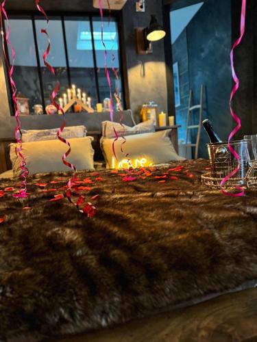 een slaapkamer met een bed met verlichting bij Le chalet romantique, SPA, Écran cinéma, Lit king size, day use, 10 min centre in Amiens