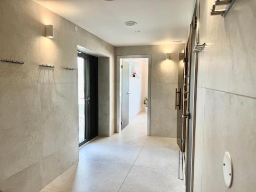 a hallway with a walk in shower in a bathroom at Wellness penzion Lázně Kvilda in Kvilda