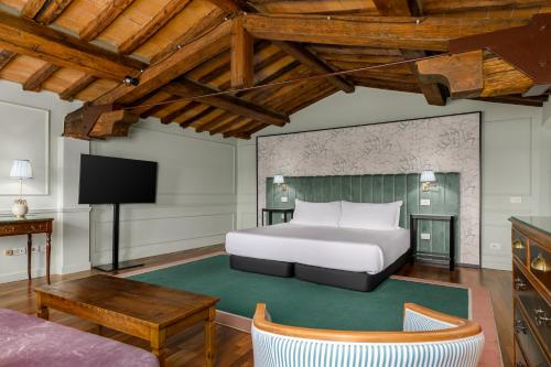 a bedroom with a bed and a tv in a room at Room Mate Collection Isabella, Florence in Florence
