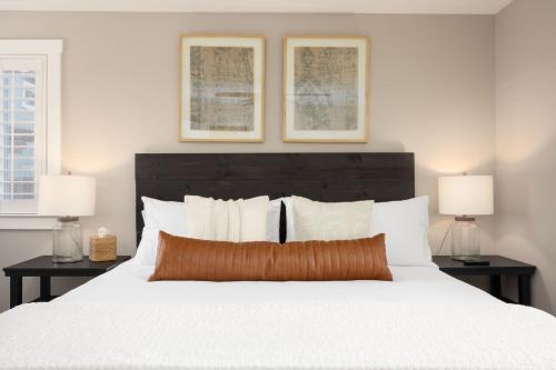 a bedroom with a large white bed with two lamps at Coastal Charm Inviting 3 BR Montara Home in Montara