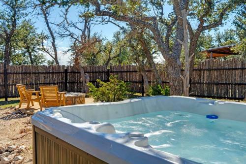 a hot tub in a backyard with a table and chairs at Rockin' R - Rustic Star Cabin in Fredericksburg