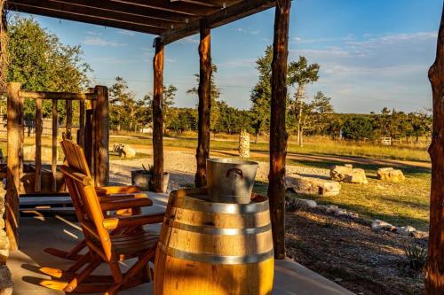 a wooden barrel and a chair on a porch at Rockin' R - Rustic Star Cabin in Fredericksburg