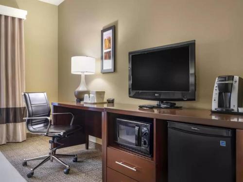a hotel room with a desk with a television and a chair at Comfort Inn Duncansville - Altoona in Duncansville