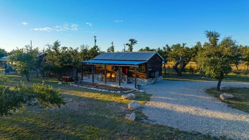 a small house with a blue roof in a field at Rockin' R - Rustic Star Cabin in Fredericksburg