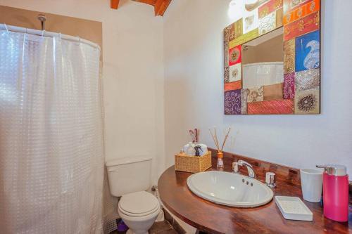 a bathroom with a sink and a toilet and a mirror at A3- Departamento con Vista Panorámica y Piscina in San Carlos de Bariloche