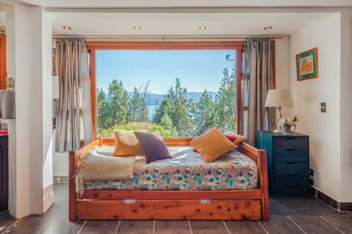 a bedroom with a bed and a large window at A3- Departamento con Vista Panorámica y Piscina in San Carlos de Bariloche