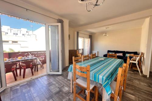 une salle à manger avec une table et un salon dans l'établissement COEUR DE CAMARGUE - Terrasse et Garage proche de la Plage, au Grau-du-Roi
